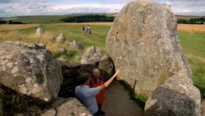 Tony Robinson looking at sarsen stones in the entrance to West Kennet longbarrow