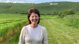 BBC Radio 4 presenter, Helen Mark, in front of a downland landscape with the Westbury White Horse
